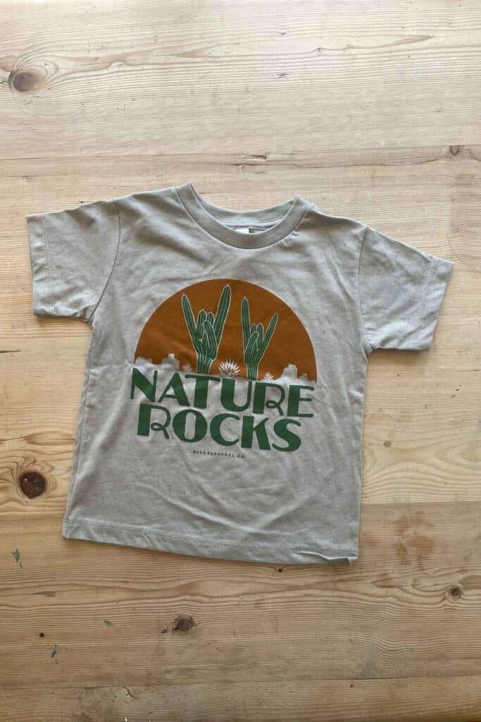 A kids t-shirt with the slogan "nature rocks" and cactus