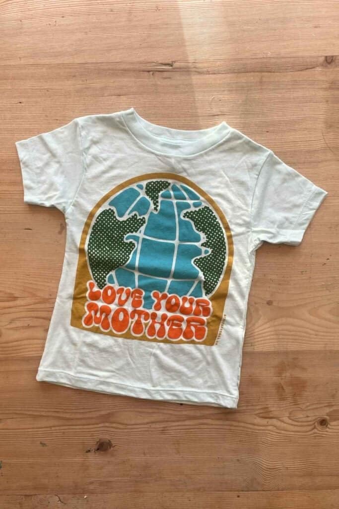 A kids t-shirt with the slogan "love your mother" and the earth