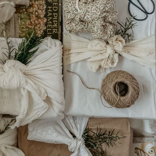 A pile of sustainably wrapped gifts - some are wrapped in fabric furoshiki, others in scrap paper and recycled tissue paper