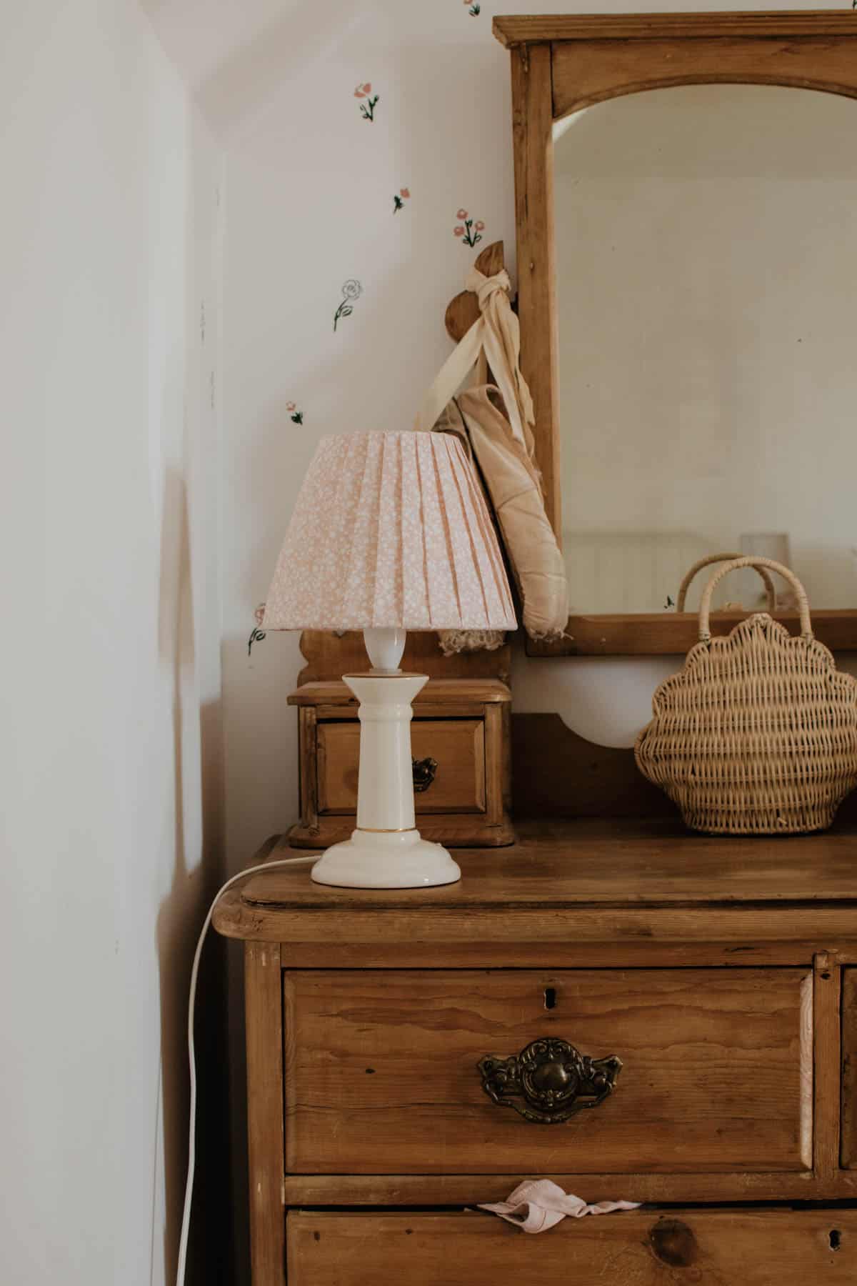 A lamp with an upcycled DIY pleated lampshade sits on an antique dresser