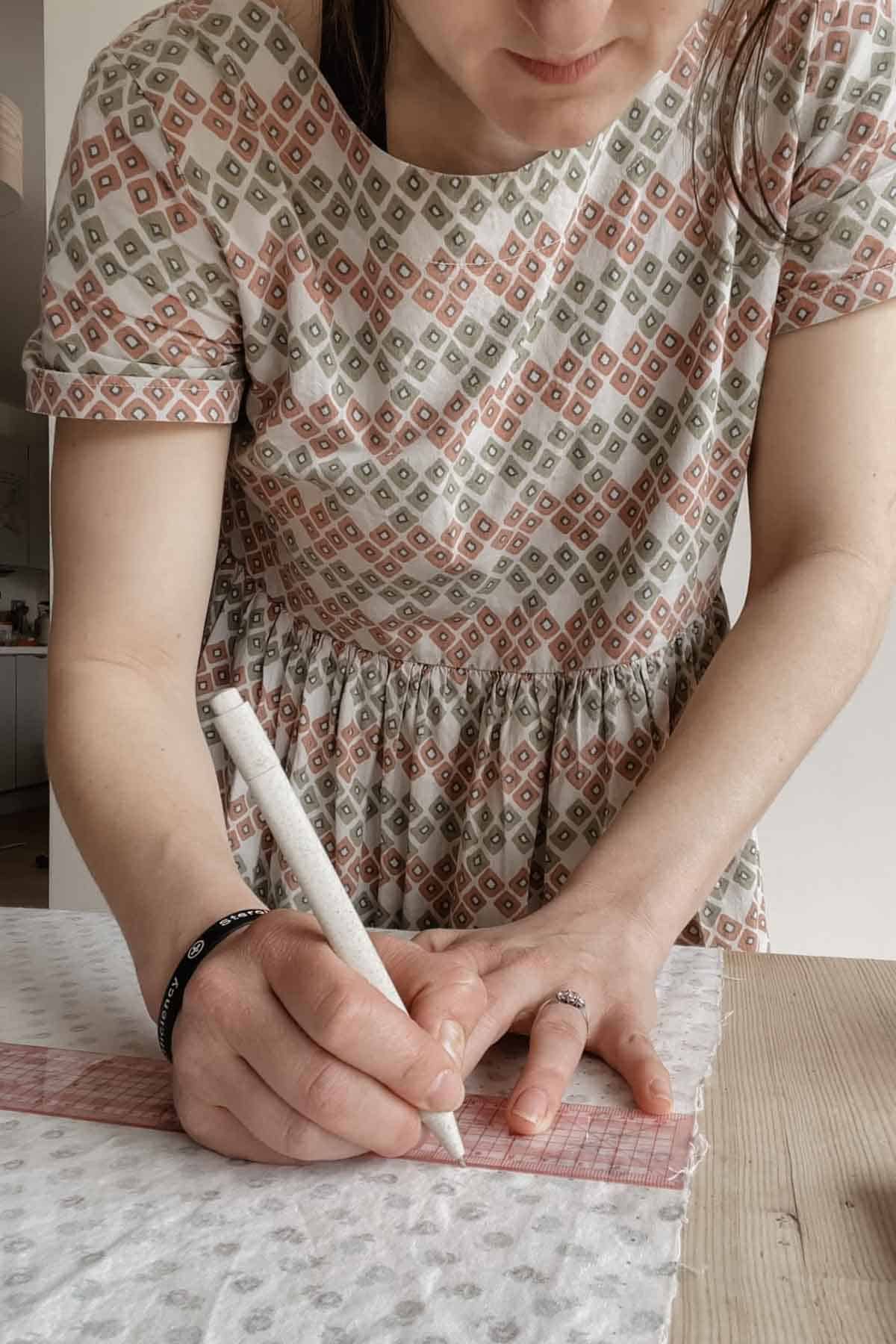 A woman marks dots ready to pleat fabric for smocking