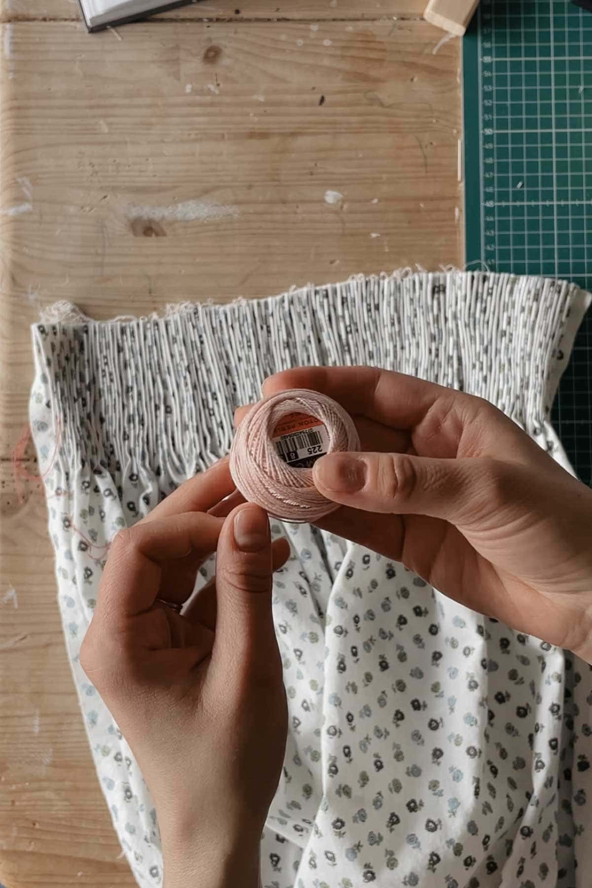 A person holds a spool of Perle Coton thread