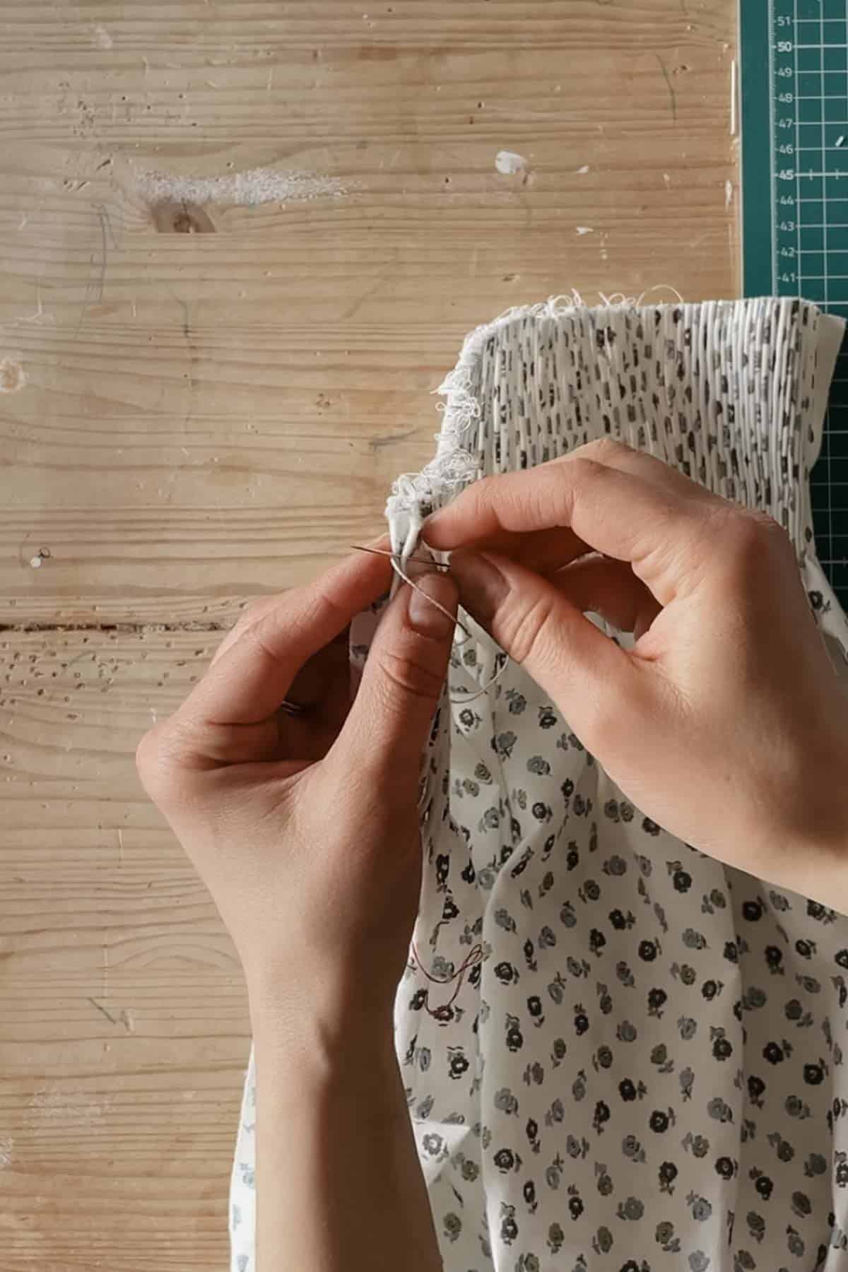 A person stitches through the second pleat