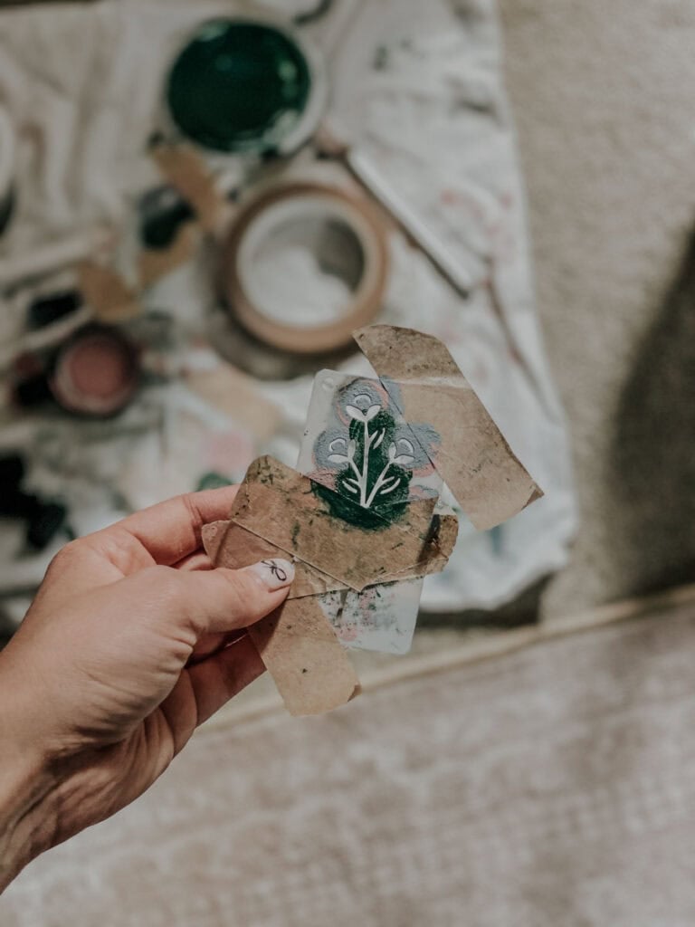 A flower stencil in front of painting supplies
