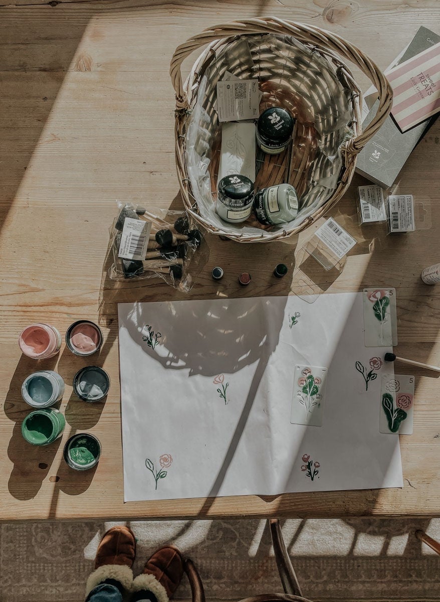 Pots of paint, flower stencils and other supplies for a flower wall stencil project