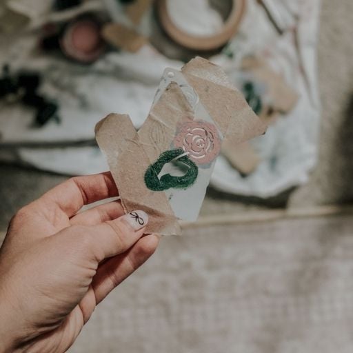 A flower stencil in front of painting supplies