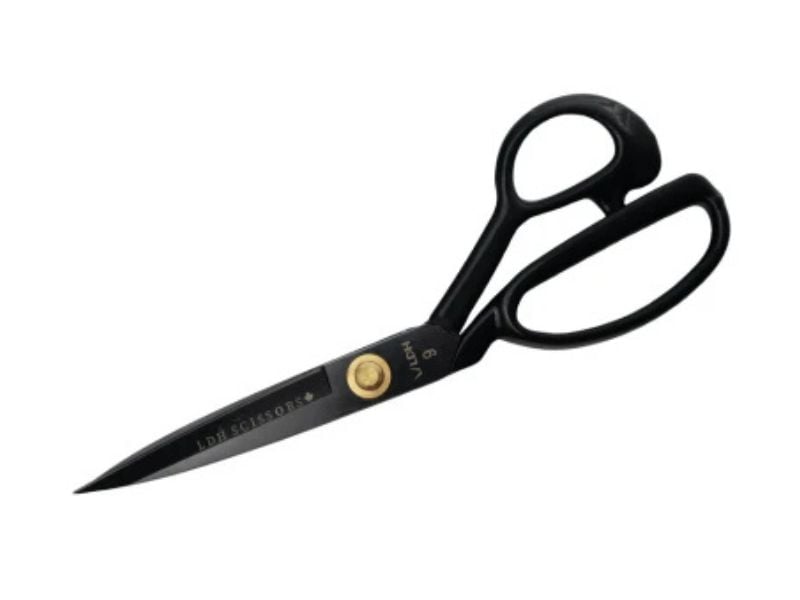A pair of black metal scissors with large handles and a golden screw at the pivot, perfect for sewing tricks that help you sew faster, photographed on a white background.